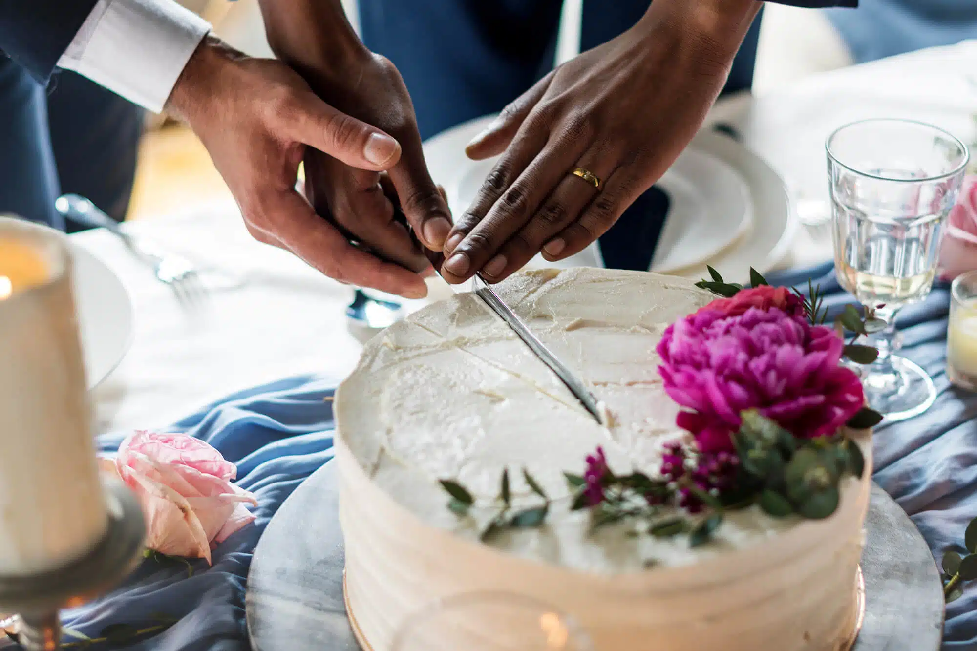 Hochzeitspaar schneidet gemeinsam die Hochzeitstorte an